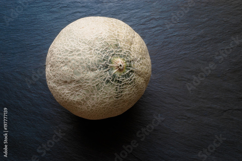 Hami Melon Fruit on Black Stone Surface Background with Free Space