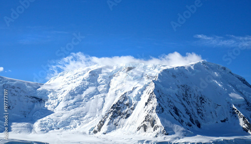 Antarctic ocean, Antarctica. Glacier Snow Covered Mountain. Dramatic blue Sky background © birdiegal