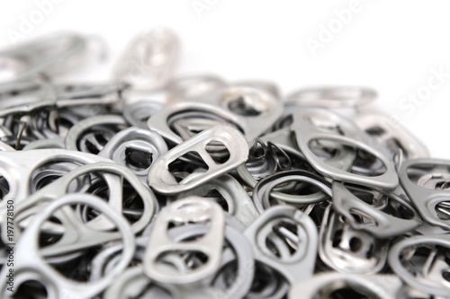Heap of ring pulls with one pull tab in focus