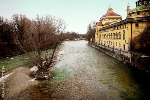 Munich, Germany - panoramic winter view of Isar river with the neo-baroque Muellersches volksbad, bath establishment built in year 1901 with  the largest swimming pool of the world at that time. photo