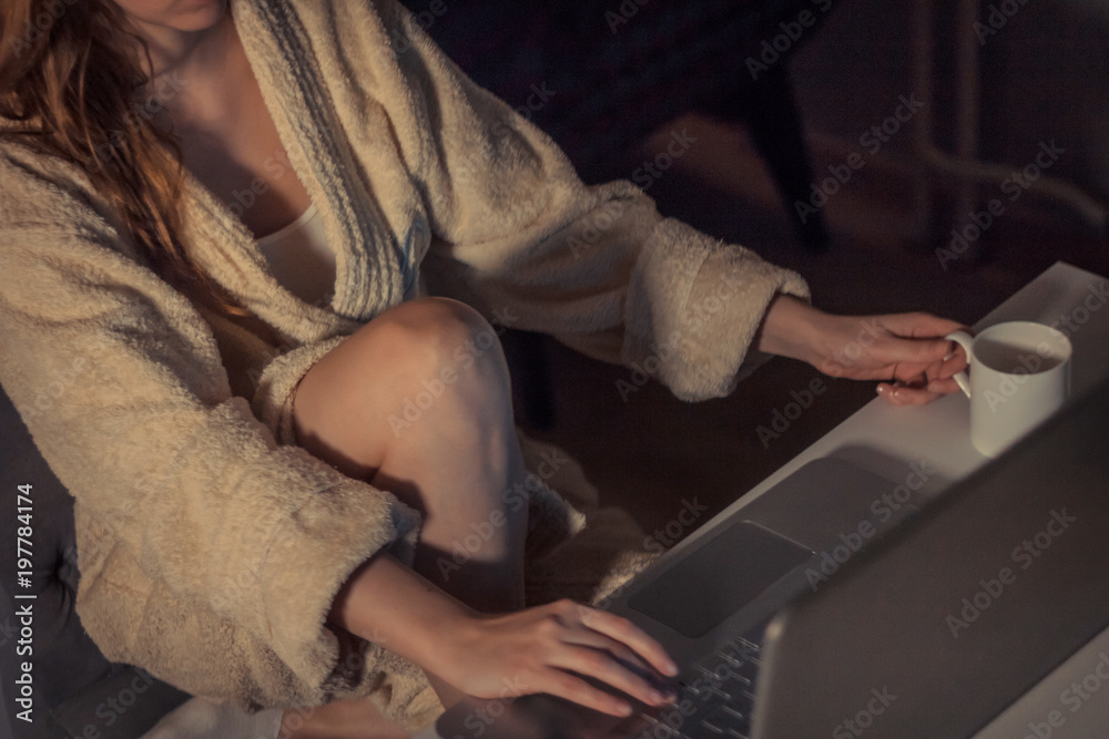 Unrecognizable woman surfing the net late in the evening.