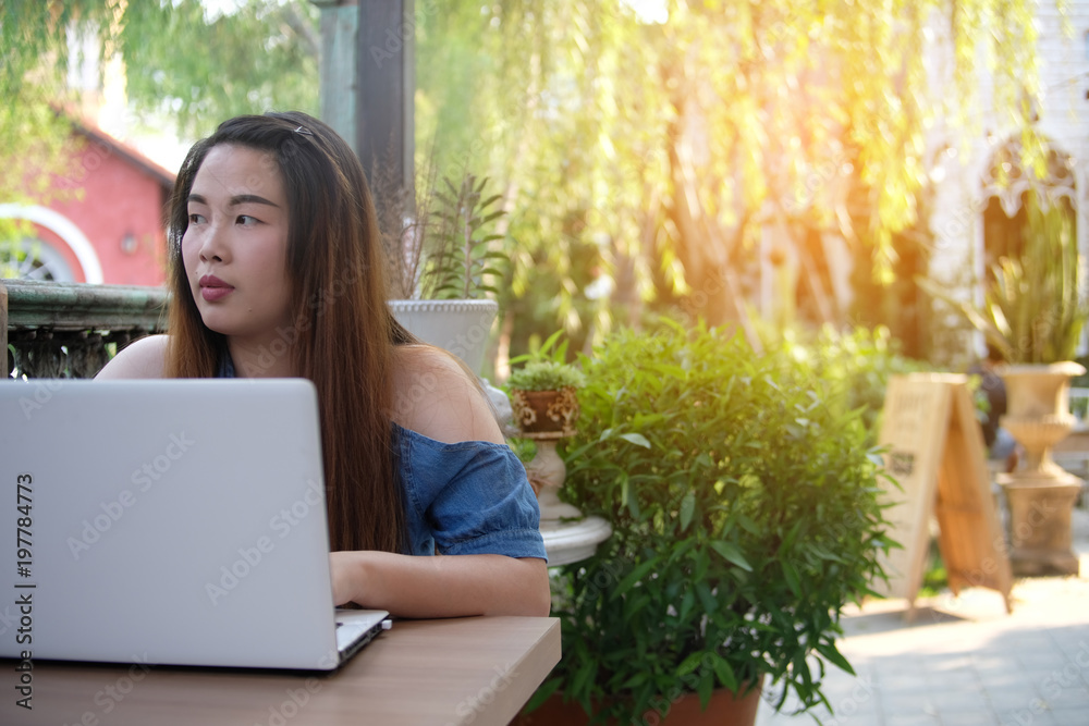 Woman with laptop on wooden table in the coffee shop, business technology