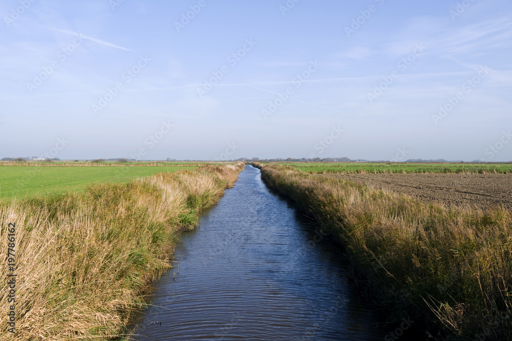 Foehr / Germany: The small „Borsumer Arm“ channel for the drainage of the marsh fields near Oldsum on the Frisian island in autumn