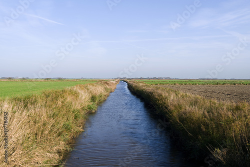 Foehr / Germany: The small „Borsumer Arm“ channel for the drainage of the marsh fields near Oldsum on the Frisian island in autumn