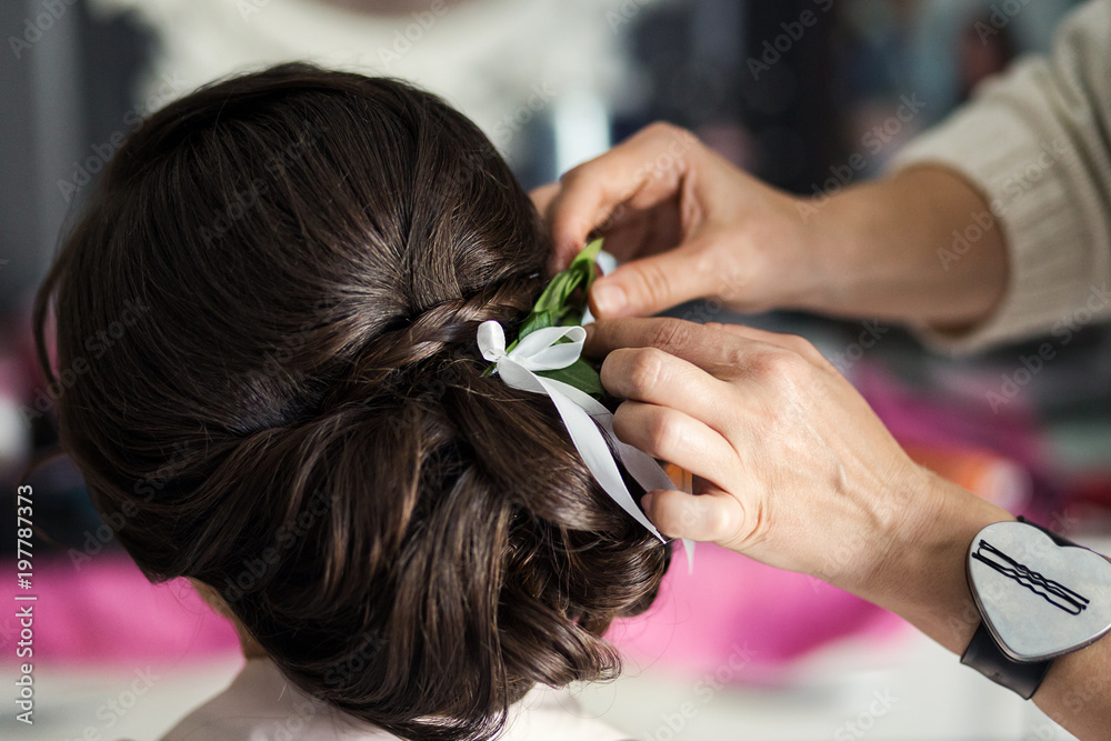 hair stylist or florist makes the bride a wedding hairstyle with fresh flowers hair stylist or florist makes the bride a wedding hairstyle with fresh flowers