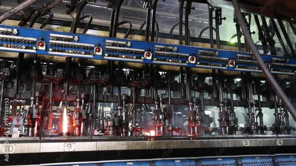 Hot Glass Is Fed From The Oven To The Glass Bottle Making Machine Hot Glass Is Fed From The Oven To The Glass Bottle Making Machine