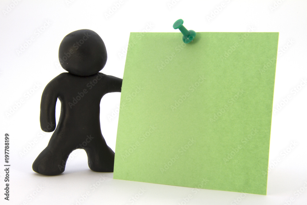 Black plasticine character and green sticker. Stationery. Isolated over white background