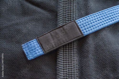 Blue belt of Brazilian Jiu-Jitsu with four degrees, on top of the kimono.