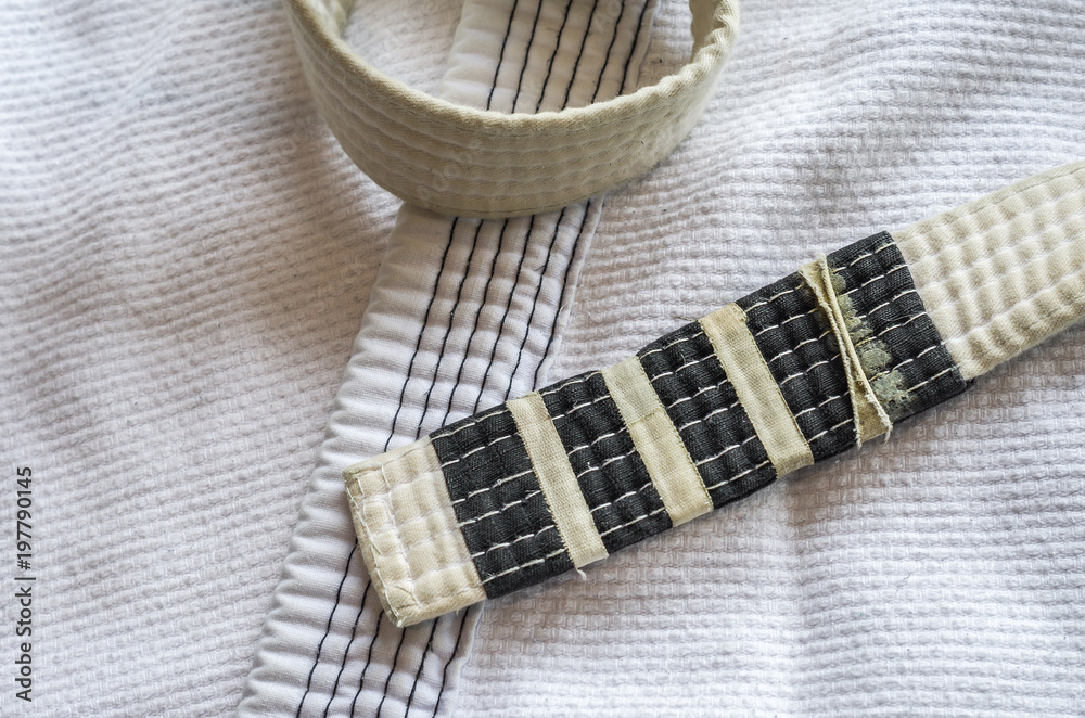 White belt of Brazilian Jiu-Jitsu with four degrees, on top of the kimono. White belt of Brazilian Jiu-Jitsu with four degrees, on top of the kimono.