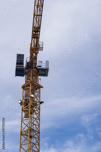 large crane against a blue sky in vertical format 