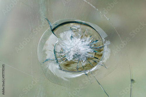 Firearms bullethole on bulletproof glass, cracks background photo