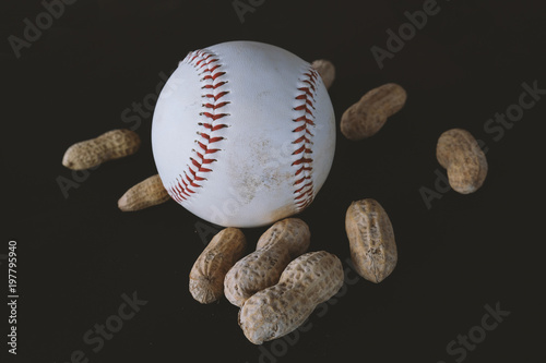 White baseball with ballpark peanuts against black background.  Ball equipment for sports graphic.