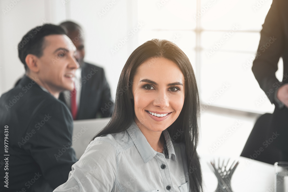 Focus on satisfied female face. Partners sitting and talking on background Focus on satisfied female face. Partners sitting and talking on background