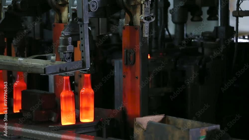 Beer bottle production. Automated Production Line of Bottle In Glass Factory. Manufacture of glass bottles. Glowing bottles after melting glass on a factory conveyor line. Production of glass bottles. Beer bottle production. Automated Production Line of Bottle In Glass Factory. Manufacture of glass bottles. Glowing bottles after melting glass on a factory conveyor line. Production of glass bottles.