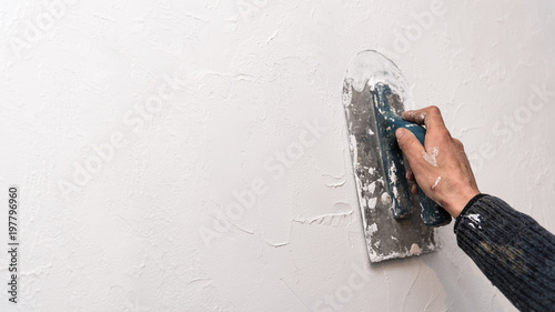 Plastering wall, work with spatula, creating relief pattern on the wall, workflow, banner with copyspace photo