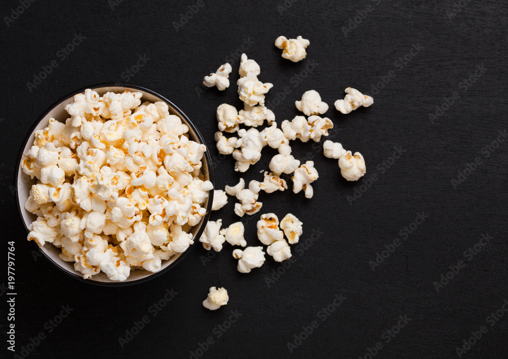 Black bowl with fresh salted popcorn on wood Black bowl with fresh salted popcorn on wood