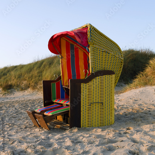 Foehr / Germany: Colorful empty hooded beach-chair at Goting beach on the south coast of the Frisian island in the deep November afternoon sun