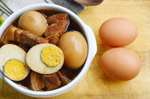 Eggs Stewed or Thai name is khai phalo muu saam chan on wooden background photo