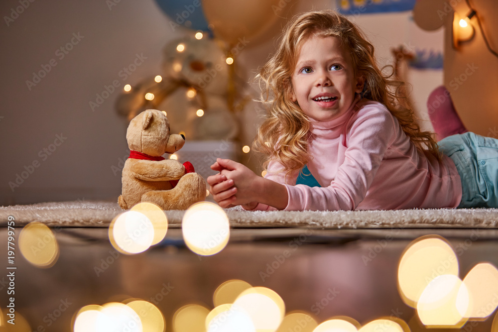 Φωτογραφία Waist up portrait of cheerful little girl toying with bear