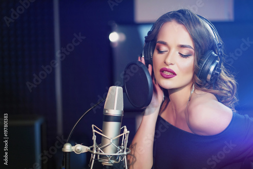 Schilderij op canvas Beautiful young singer who recorded a song in a professional recording studio