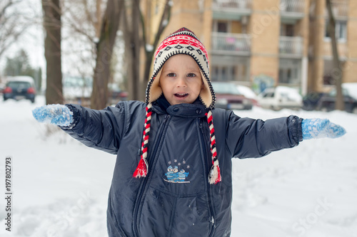 The boy poses in winter joys in the snow 