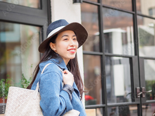 Beautiful young brunette woman working carring bag with happy expression. Outdoor fashion portrait of glamour young Chinese business stylish lady. Emotions, people, beauty and lifestyle concept. photo