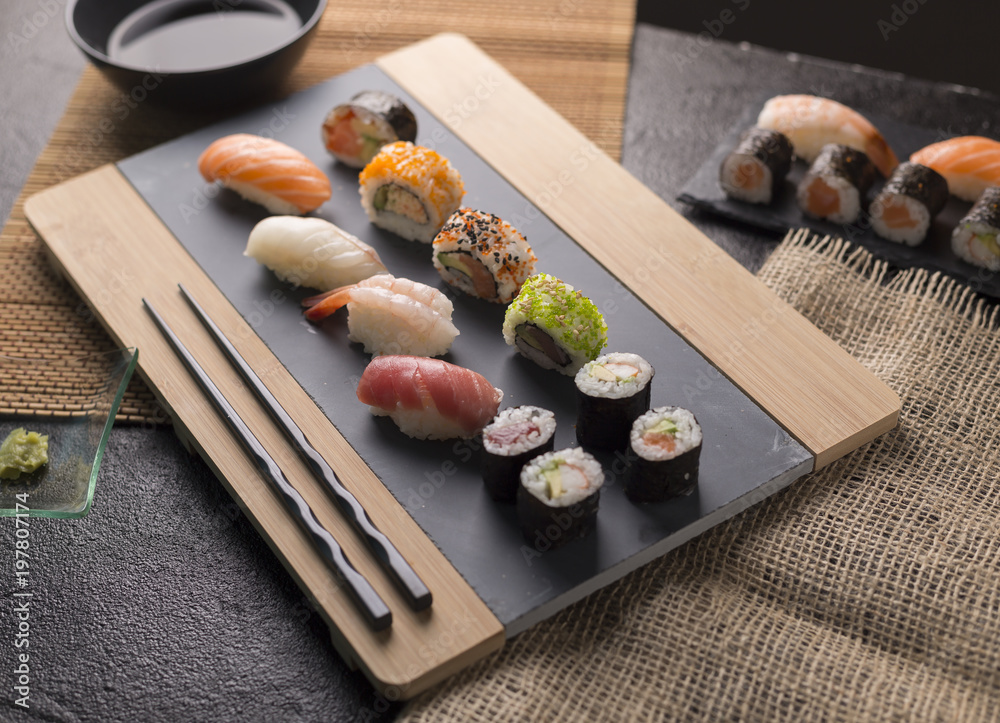Sushi Set sashimi and sushi rolls served on stone slate - obrazy, fototapety, plakaty 