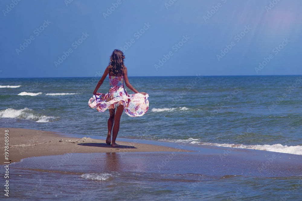 Fashion photo of happy beautiful young brunette girl at sea against water and blue sky. (travel, happiness, summer rest, freedom concept). Fashion photo of happy beautiful young brunette girl at sea against water and blue sky. (travel, happiness, summer rest, freedom concept).