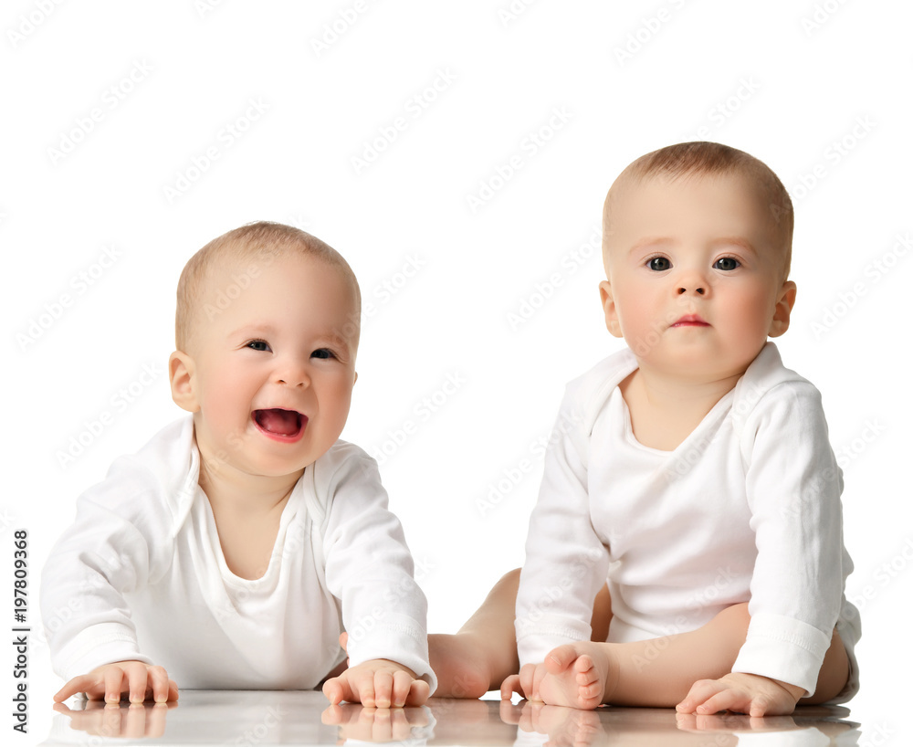 Two twin sisters infant child baby girls toddler sitting in white shirt happy smiling Two twin sisters infant child baby girls toddler sitting in white shirt happy smiling
