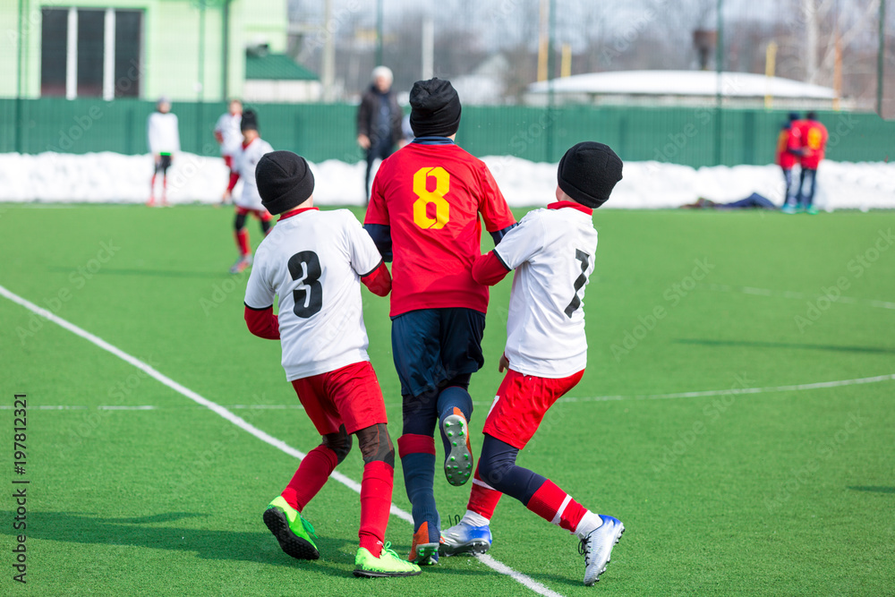 young boys play football, show dribbling, make passes to win on the winter field young boys play football, show dribbling, make passes to win on the winter field