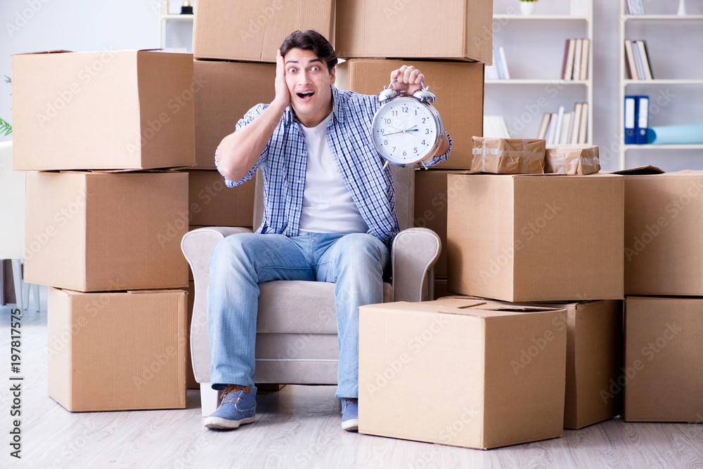 Young man moving in to new house with boxes Young man moving in to new house with boxes