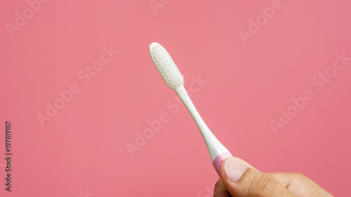 Men holding new toothbrush on a pink background. © supaleka