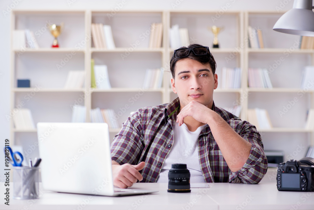 Fototapeta premium Young photographer sitting at the desk