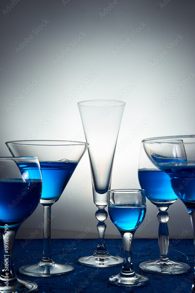 Many glasses with blue champagne or cocktail.