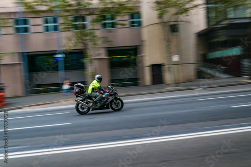 A motorcycle moving on the road  Sydney  Australia. A motorcycle in motion on the road  blurred building in background.
