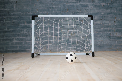 Photography A soccer ball in a small gate on a gray background