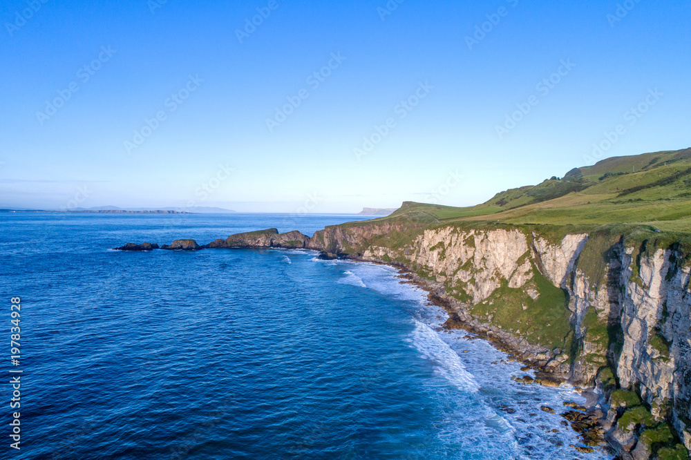 Northern Ireland, UK. Atlantic coast with cliffs and far aerial view of Carrick-a-Rede National Trust in County Antrim