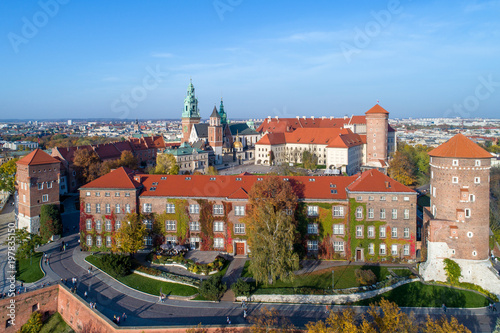 Royal Wawel Gothic Cathedral in Cracow, Poland, with Renaissance Sigismund Chapel with golden dome, Wawel Castle, yard, park and tourists. Aerial view in sunset light