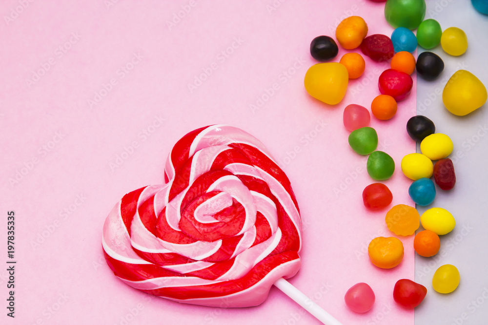 Lollipop in the shape of heart on colorful background