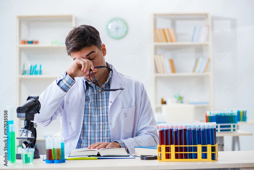 Young chemist student working in lab on chemicals Young chemist student working in lab on chemicals