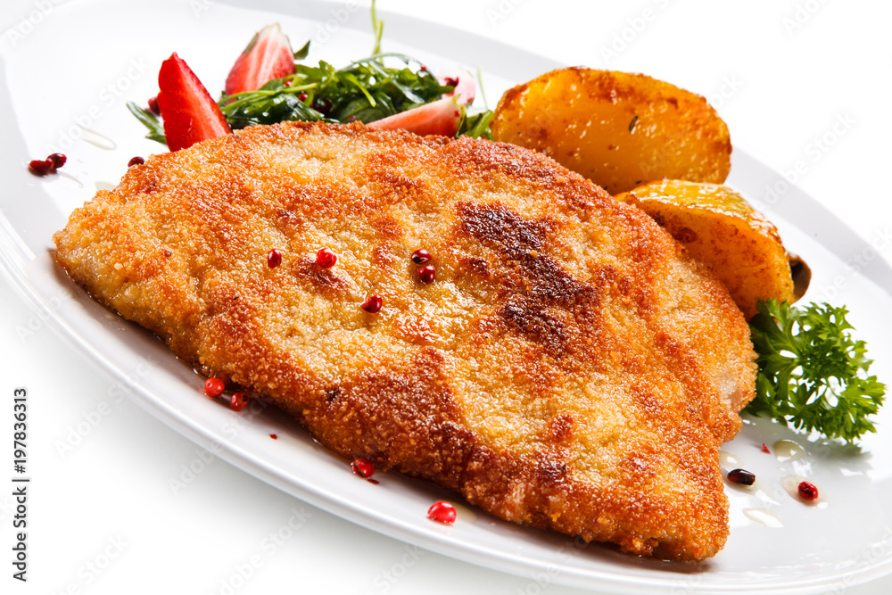 Fried pork chop, baked potatoes and vegetable salad Fried pork chop, baked potatoes and vegetable salad