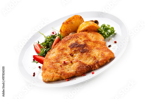 Fried pork chop, baked potatoes and vegetable salad