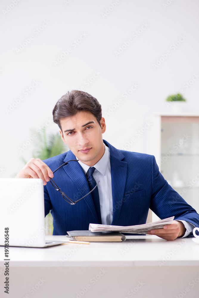 Young handsome businessman employee working in office at desk Young handsome businessman employee working in office at desk