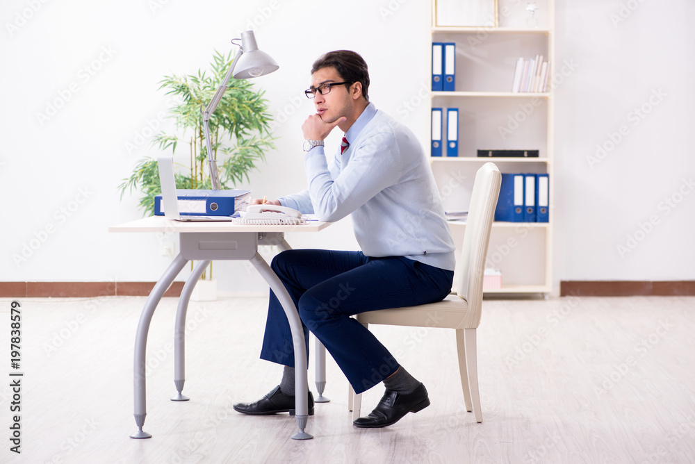 Young handsome businessman employee working in office at desk Young handsome businessman employee working in office at desk