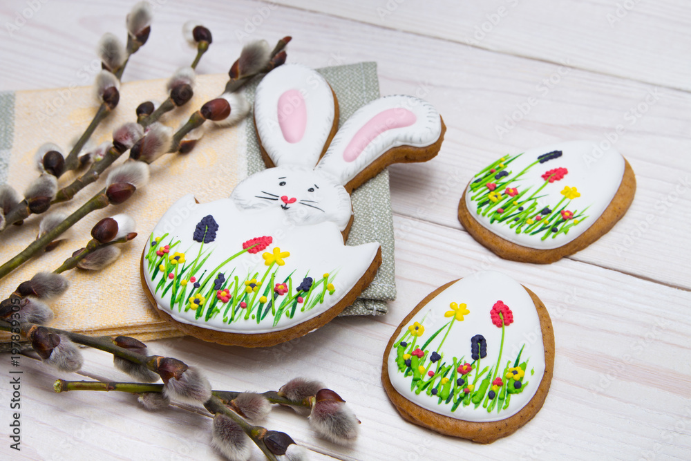 Easter gingerbread set and willow twig on white wooden background.  Easter Bunny and eggs, gingerbread
