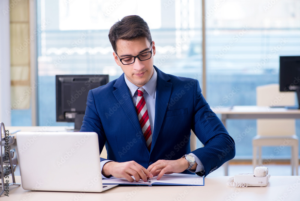 Young handsome businessman employee working in office at desk Young handsome businessman employee working in office at desk