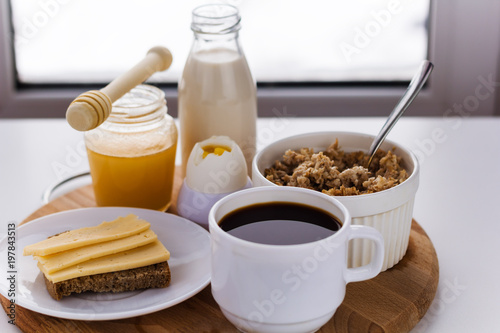 healthy foods for breakfast, milk,honey, cereal, coffee, hard boiled egg , coffee , sandwich with cheese