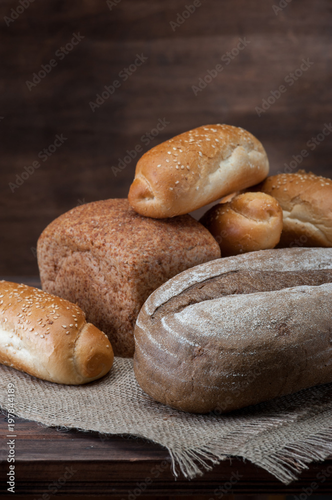 Assortiment of Bread with textured fabric on wooden background vertical