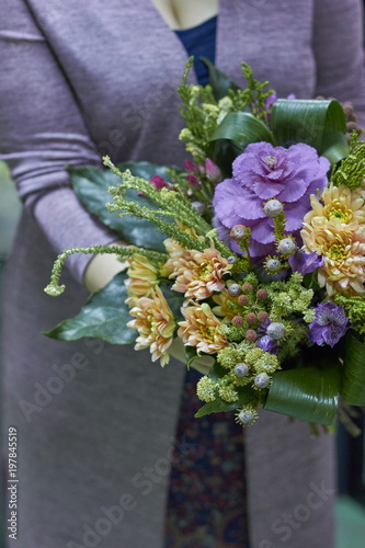 The girl is holding a bouquet of greens, leaves. Forest, natural eco bouquet. photo
