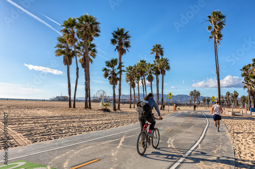 Men biking and running on Santa Monica bike path photo